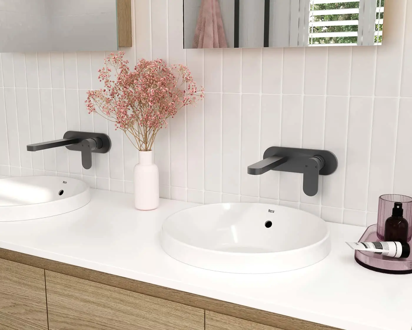 Modern bathroom with double white sinks, black wall-mounted faucets, pink dried flowers, and white tile backsplash.
