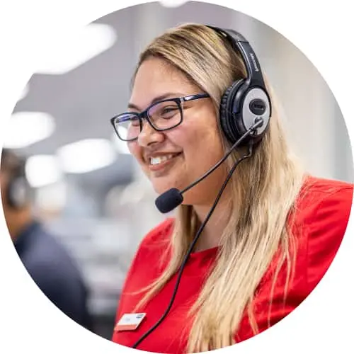 Customer service representative wearing headset and glasses smiling in an office environment