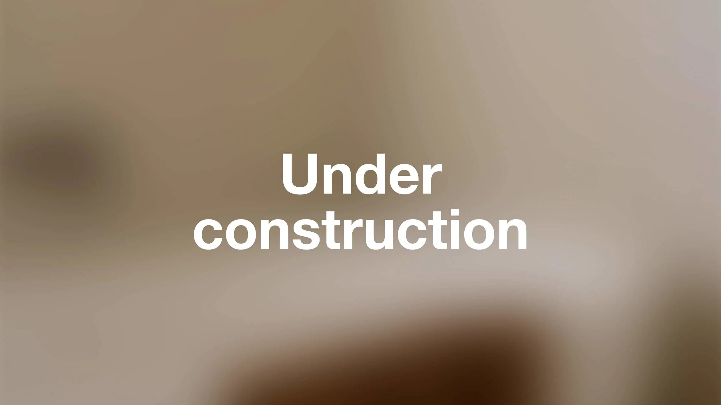 White bold text reading "Under construction" centered on a blurred beige and brown background.