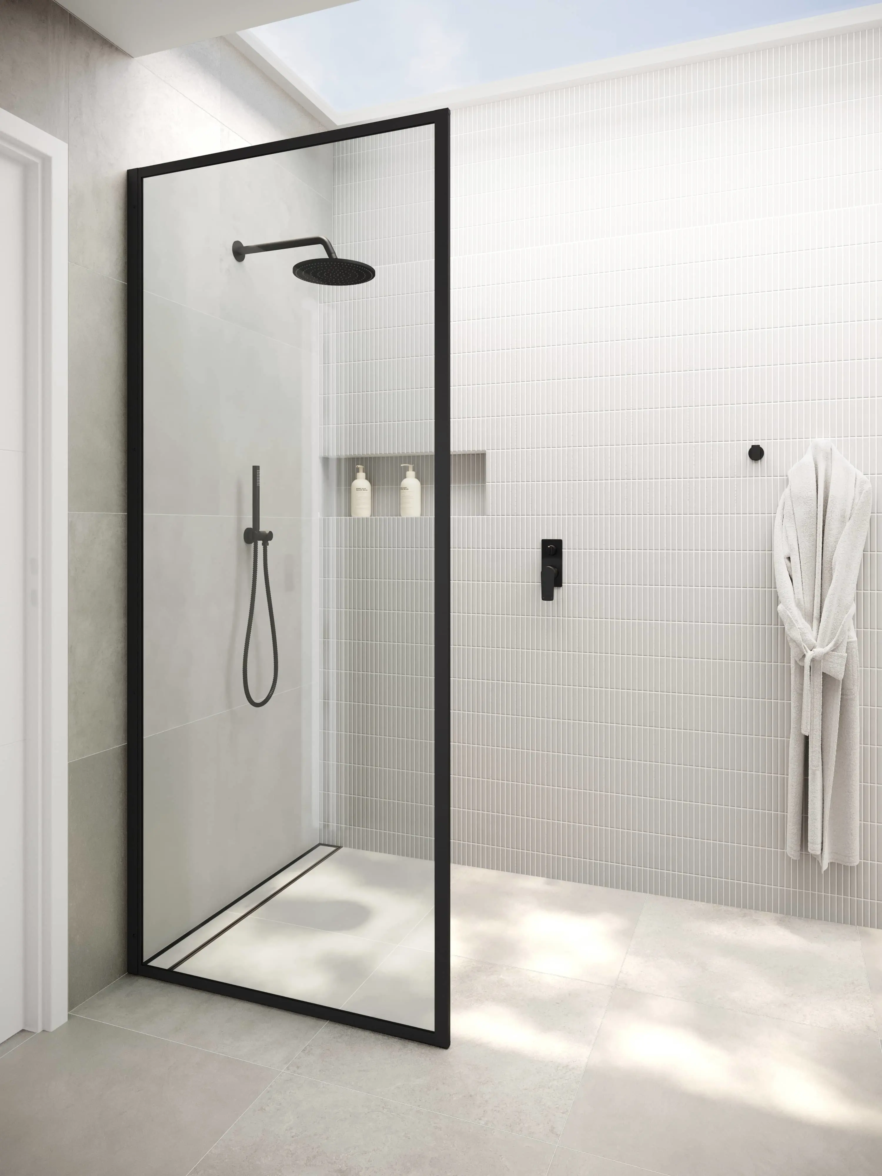 Modern walk-in shower with black frame glass door, white tiled walls, rainfall showerhead, and white bathrobe hanging nearby.