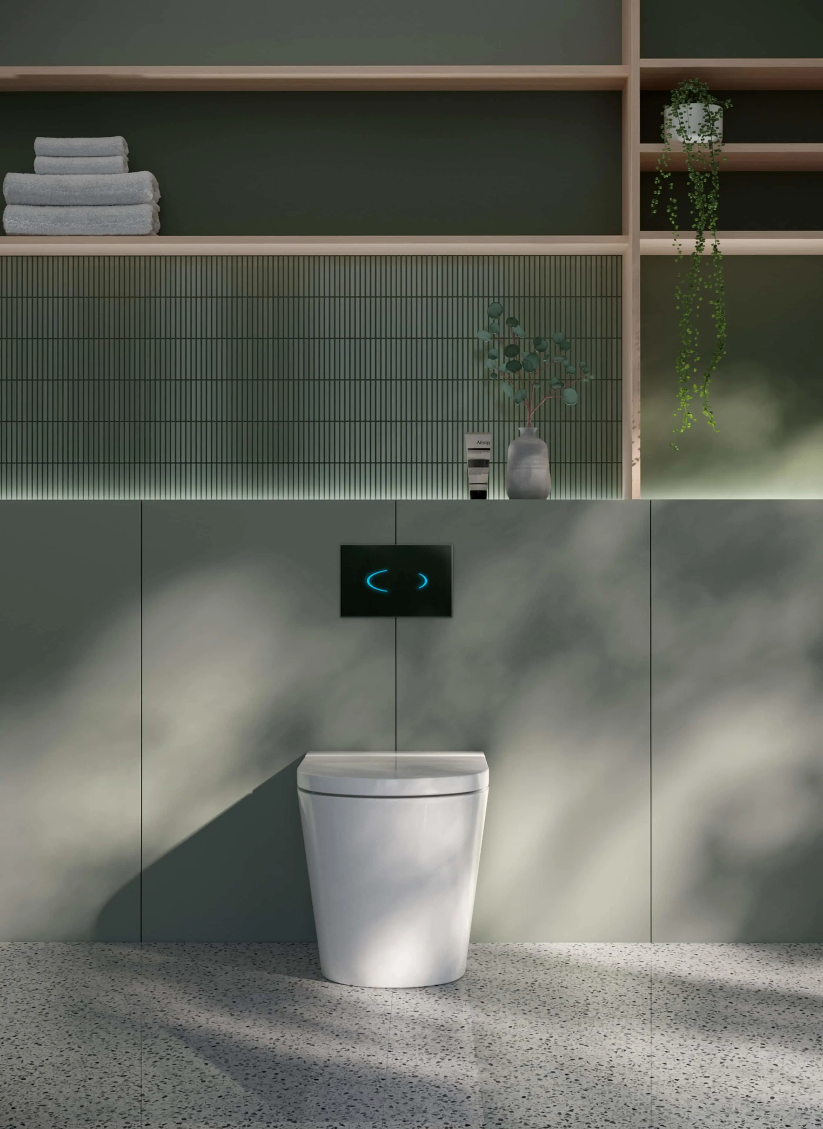 Modern bathroom with white toilet, green tiled wall, wooden shelving with folded towels and hanging plant.