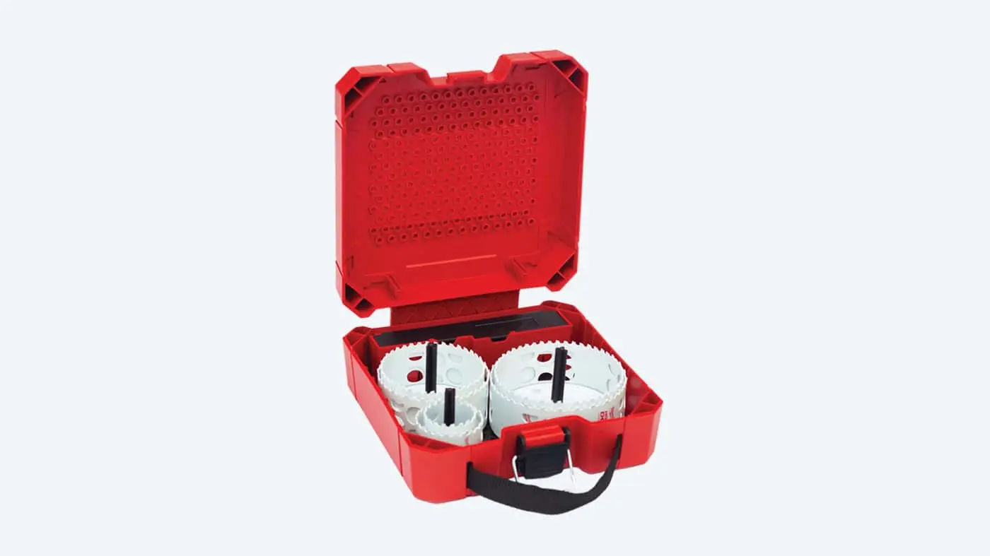 Red plastic tool case containing white circular hole saw blades with black center attachments.