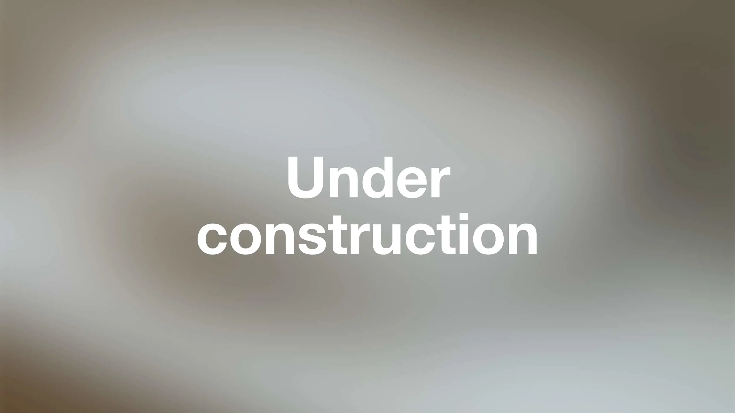 White bold text reading "Under construction" on a blurred gray and beige background.