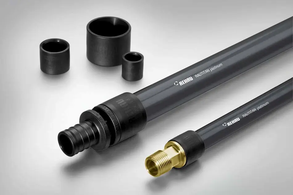 REHAU plumbing pipes with black connectors and brass fitting, alongside three black cylindrical coupling pieces.