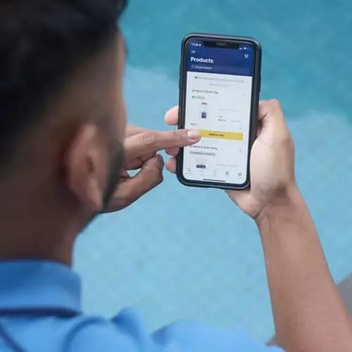 Person browsing products on a smartphone app with a yellow button, against a blue background.