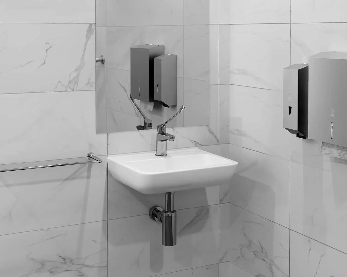 Modern bathroom sink with white marble-look tiles, chrome faucet, and wall-mounted soap and paper towel dispensers.