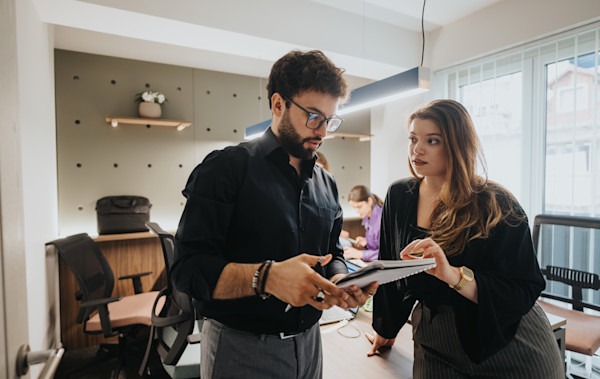 A man and a woman intensely discuss a topic in an office setting