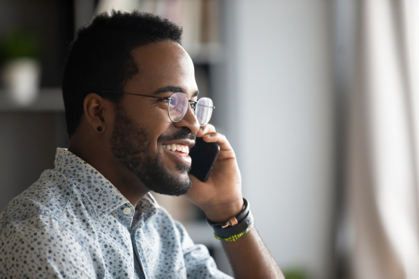 Black man with glasses talking on the phone