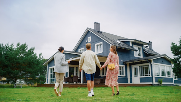 Couple holding hands looking at a house
