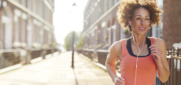 A woman jogging while listening to headphones.