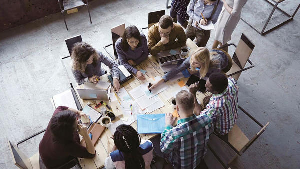 Group of employees on their computers working around a table