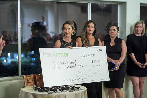 Women hold a giant check