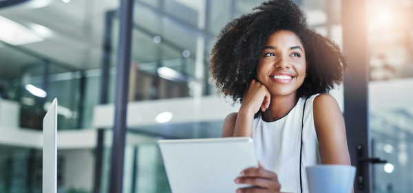 A smiling woman holding a tablet.