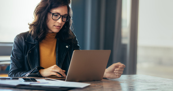 Woman wearing glasses looking at her laptop