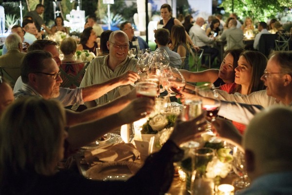 A group of people clink glasses around a table