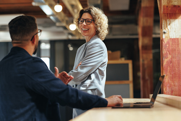 A male and female office workers having a conversation
