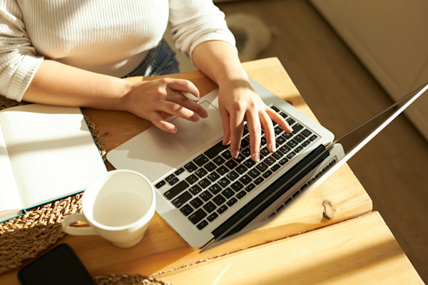 Close up of hands typing on a laptop
