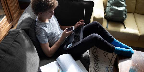 Boy on couch using laptop with pencil behind ear. JPG