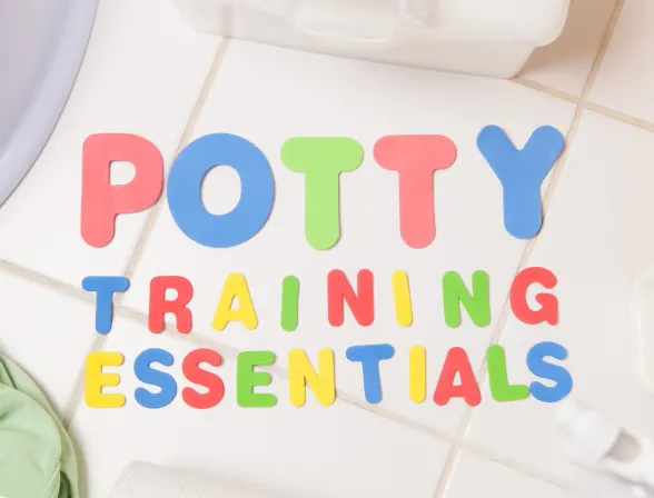 Foam letters spelling ‘Potty Training’ on a bathroom tile floor
