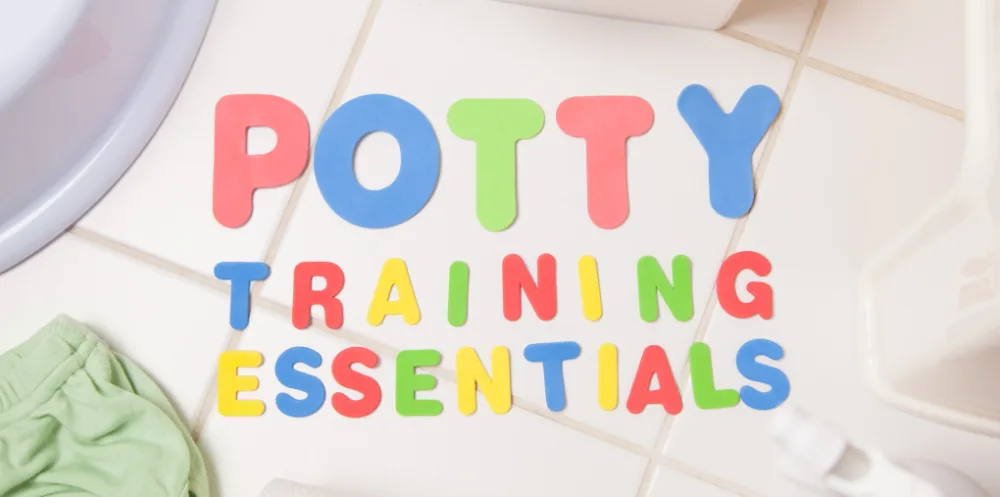 Foam letters spelling 'Potty Training' on a bathroom tile floor