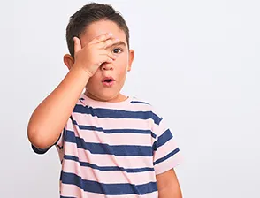 Boy covering his face with his hand