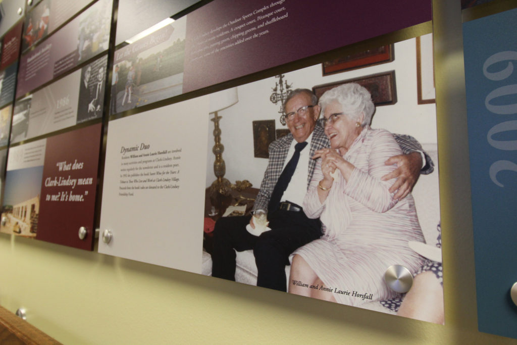 A close up the history wall. This allows you to see a panel featuring two smiling residents. Next to them is copy describing this dynamic duo.