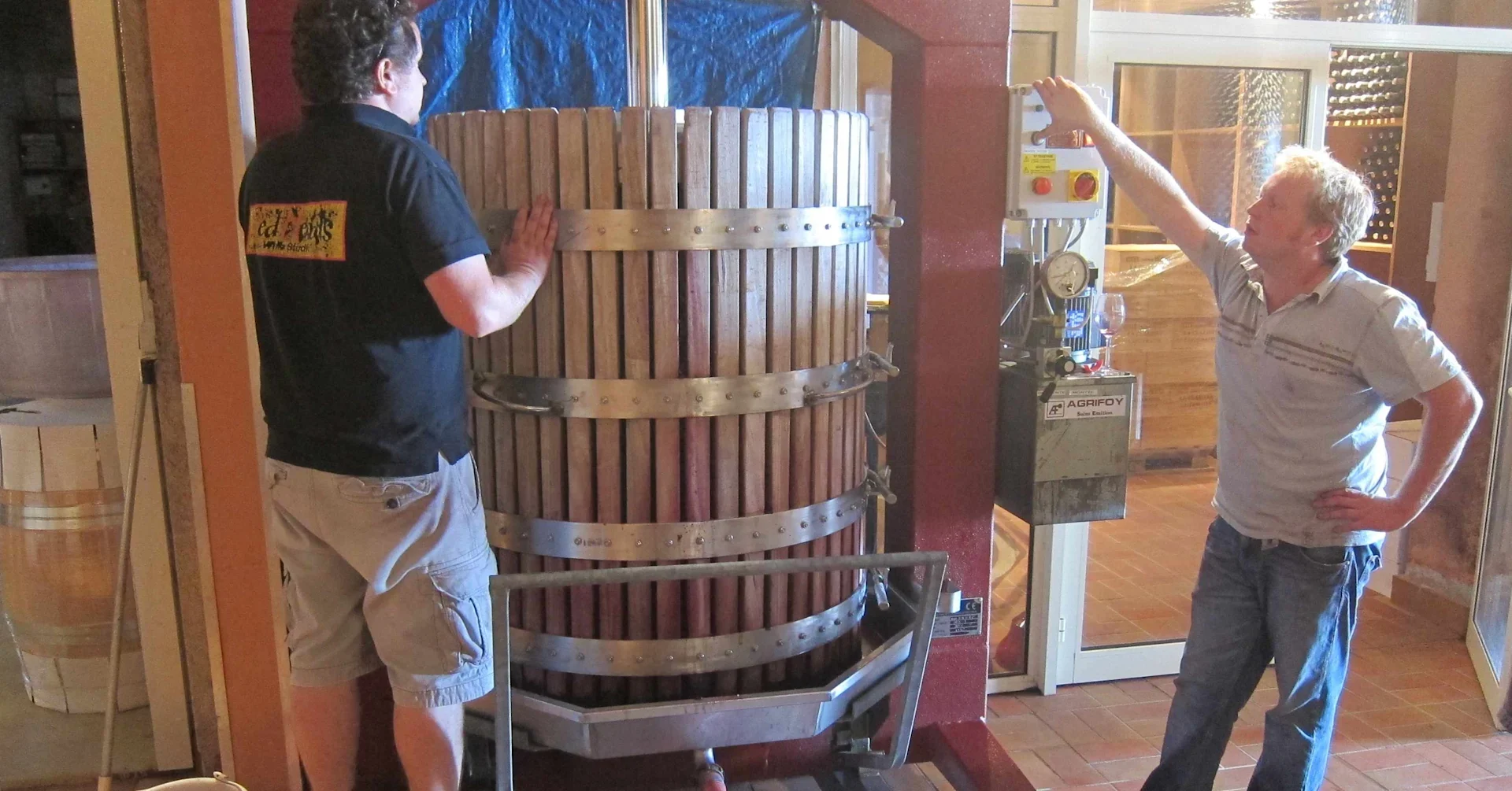 Tom and Henry Laithwaite standing by an old-fashioned basket press
