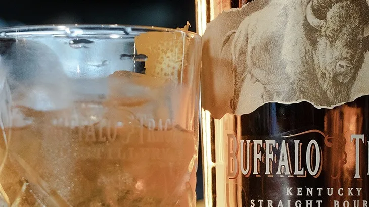 Buffalo Trace bourbon beside a cocktail served over ice.