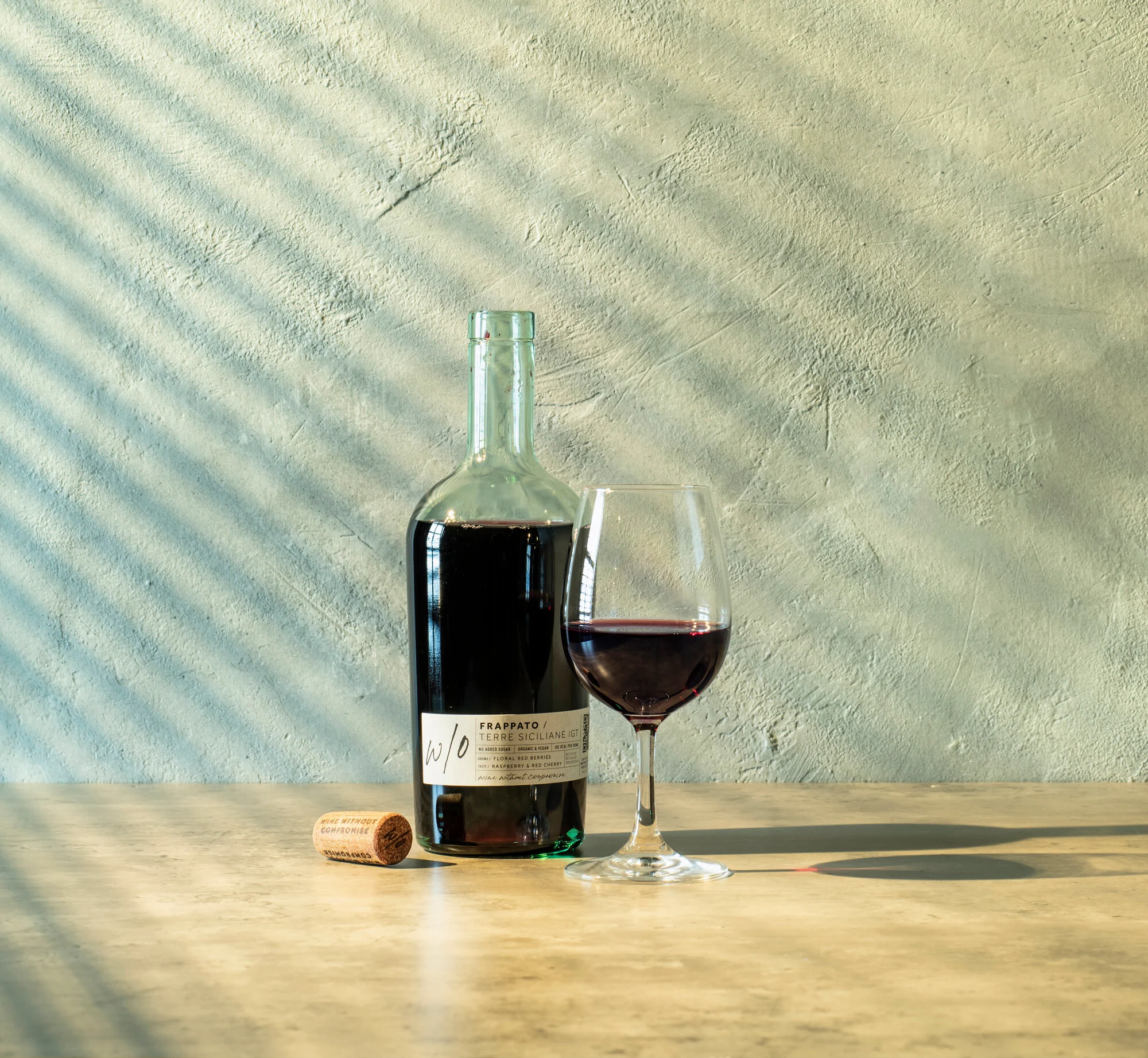 Bottle of Frappato red wine displayed beside a glass of wine.
