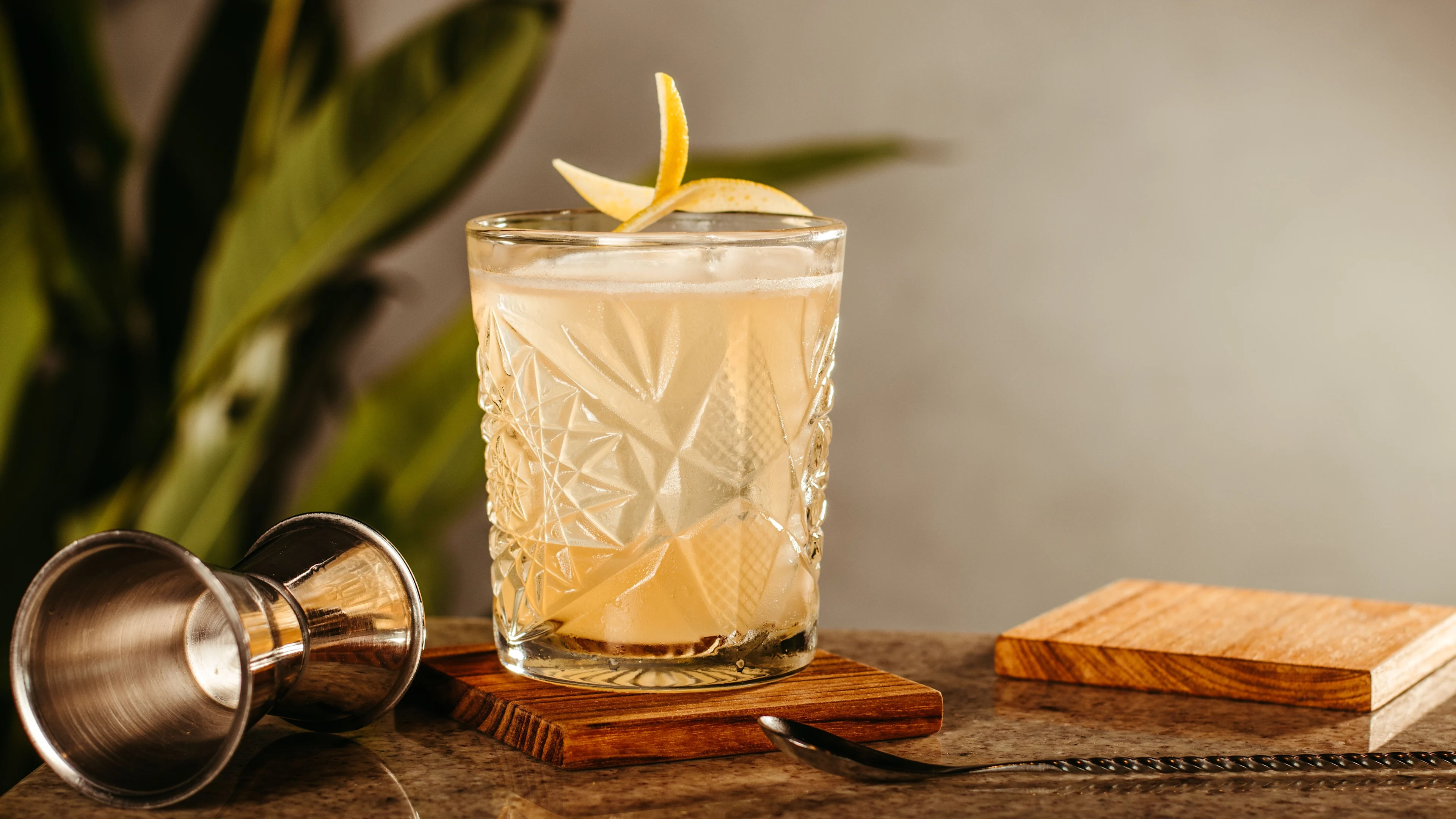 Whiskey sour cocktail served in a crystal-cut glass.
