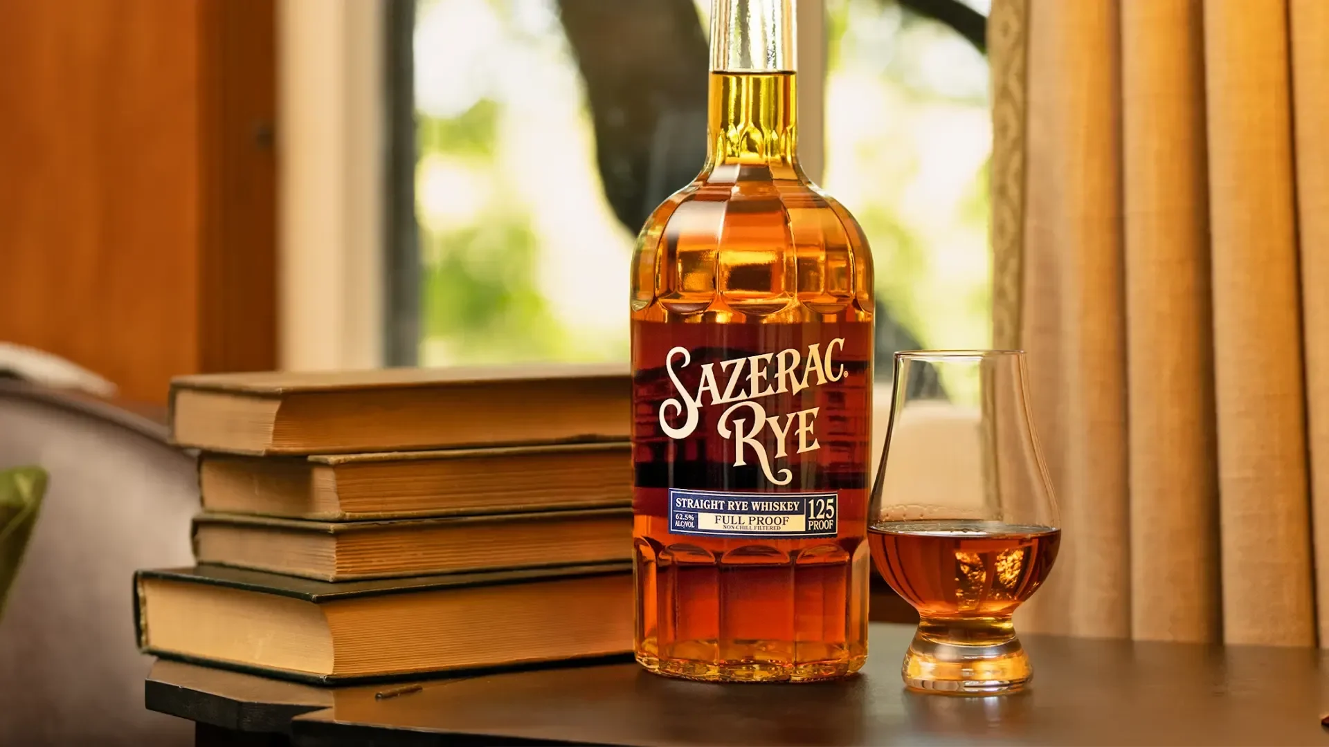 Bottle of Sazerac Rye 125 Proof whiskey beside a tasting glass.