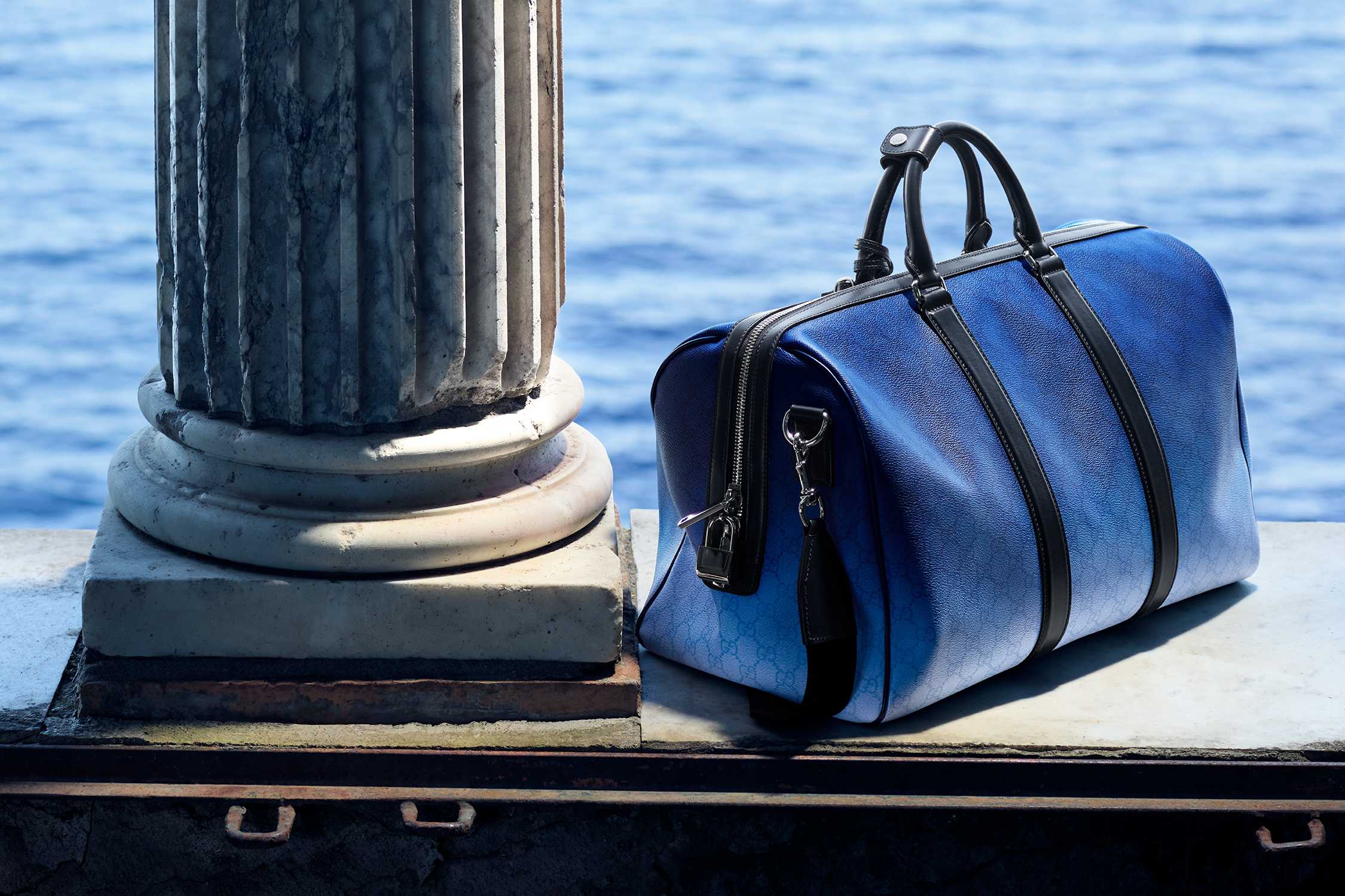 Blue Gucci duffle bag waterside.