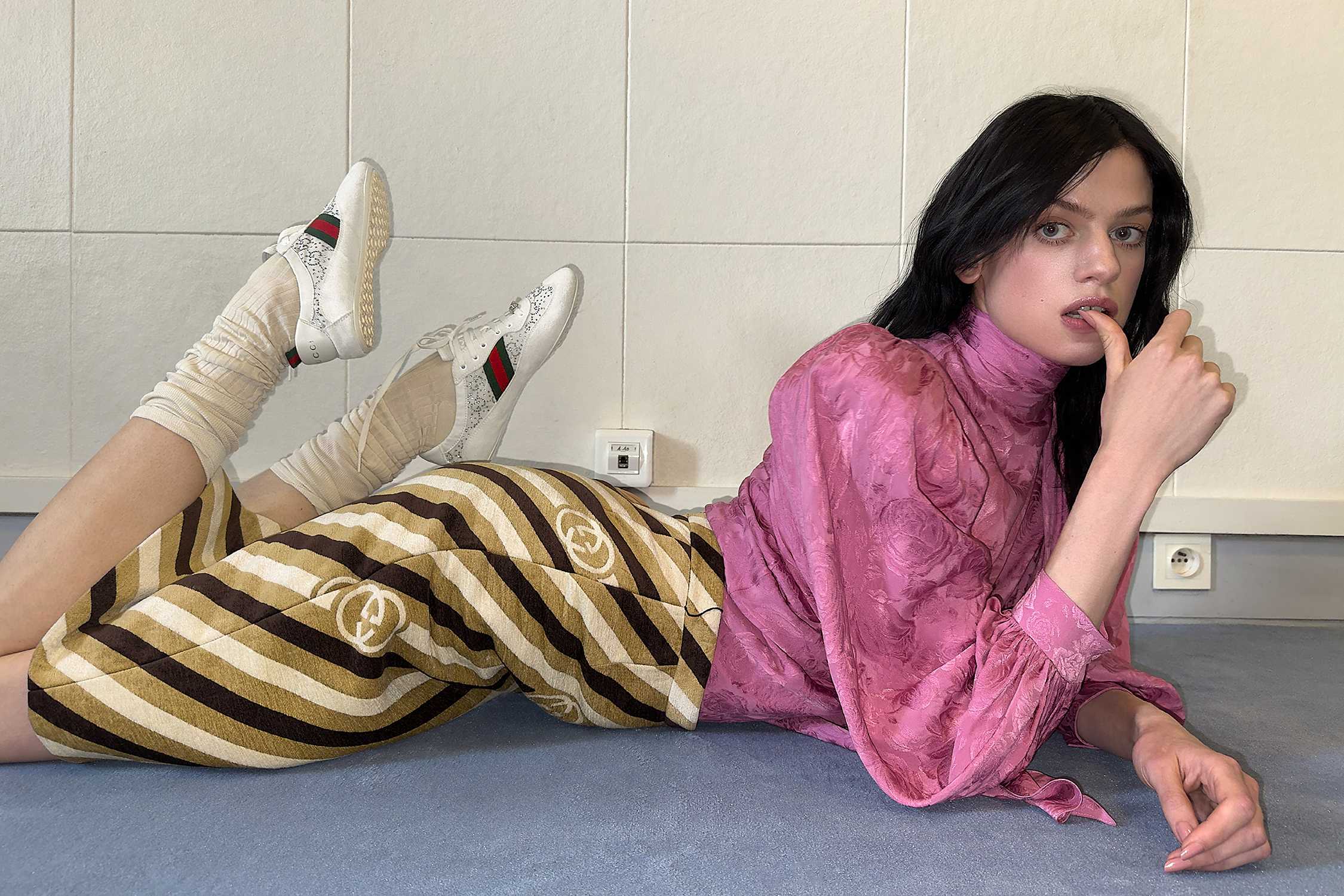 White Gucci sneakers, striped pants.