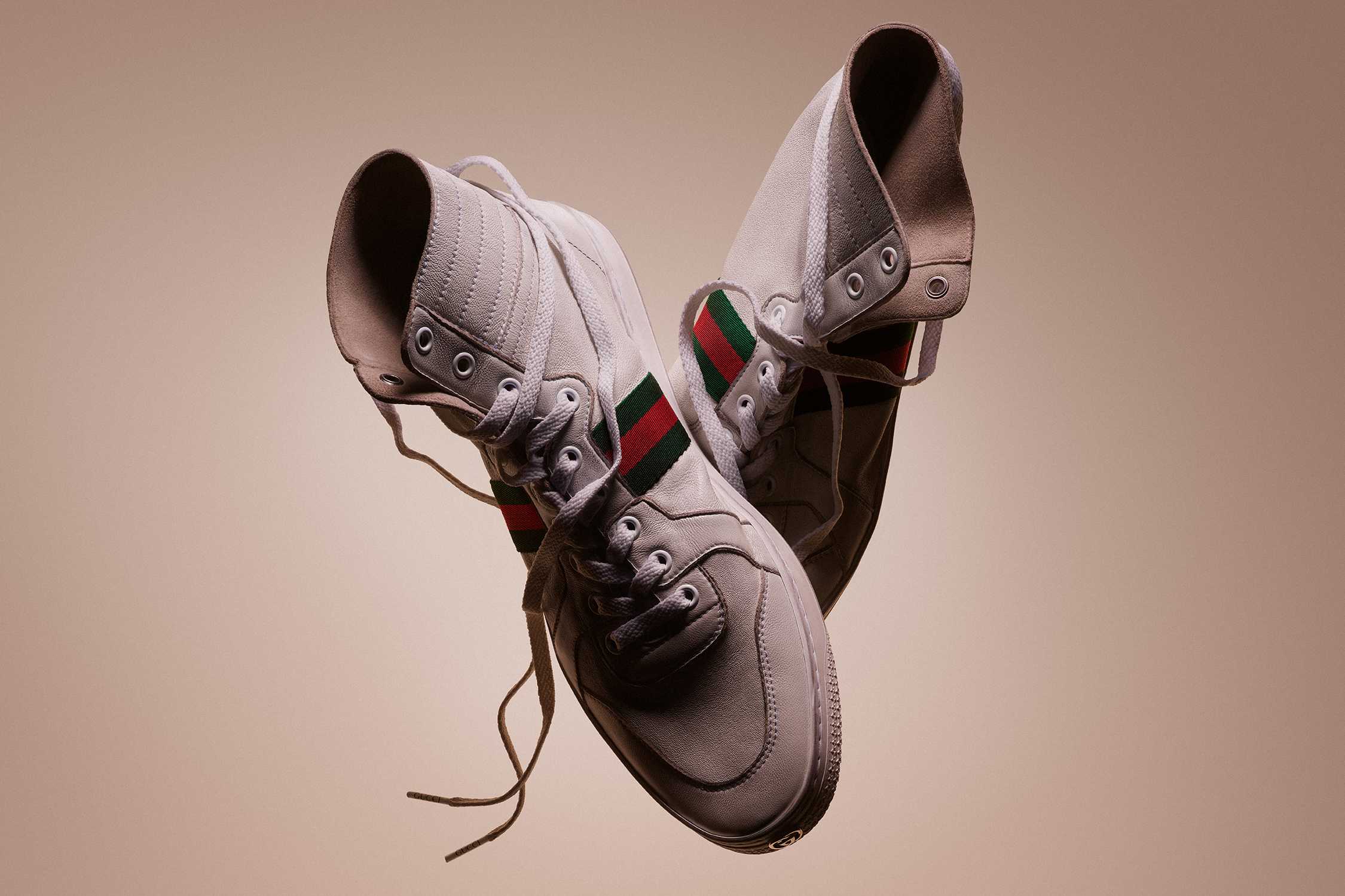 White Gucci sneakers with red-green stripe.