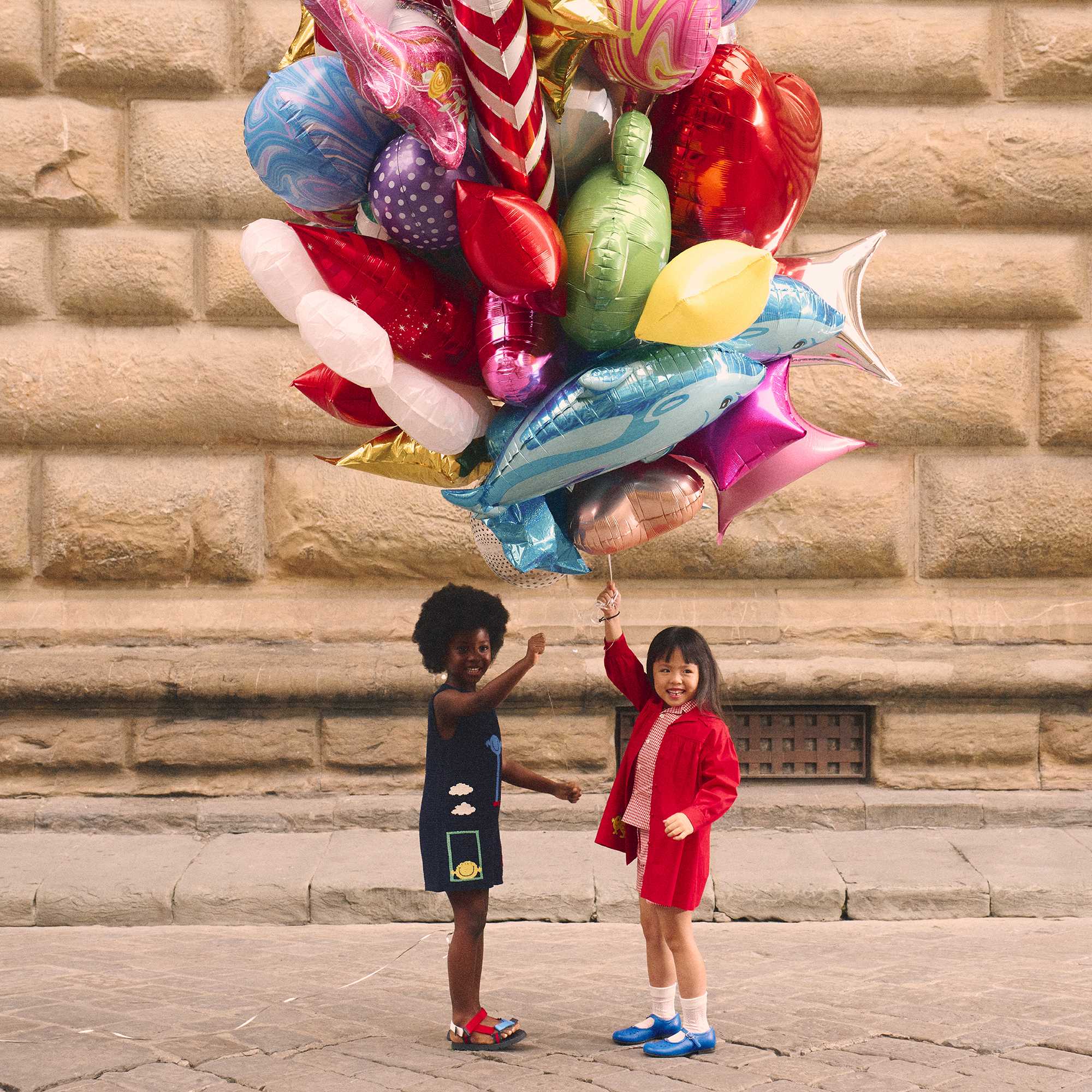 Children holding bouquet of balloons
