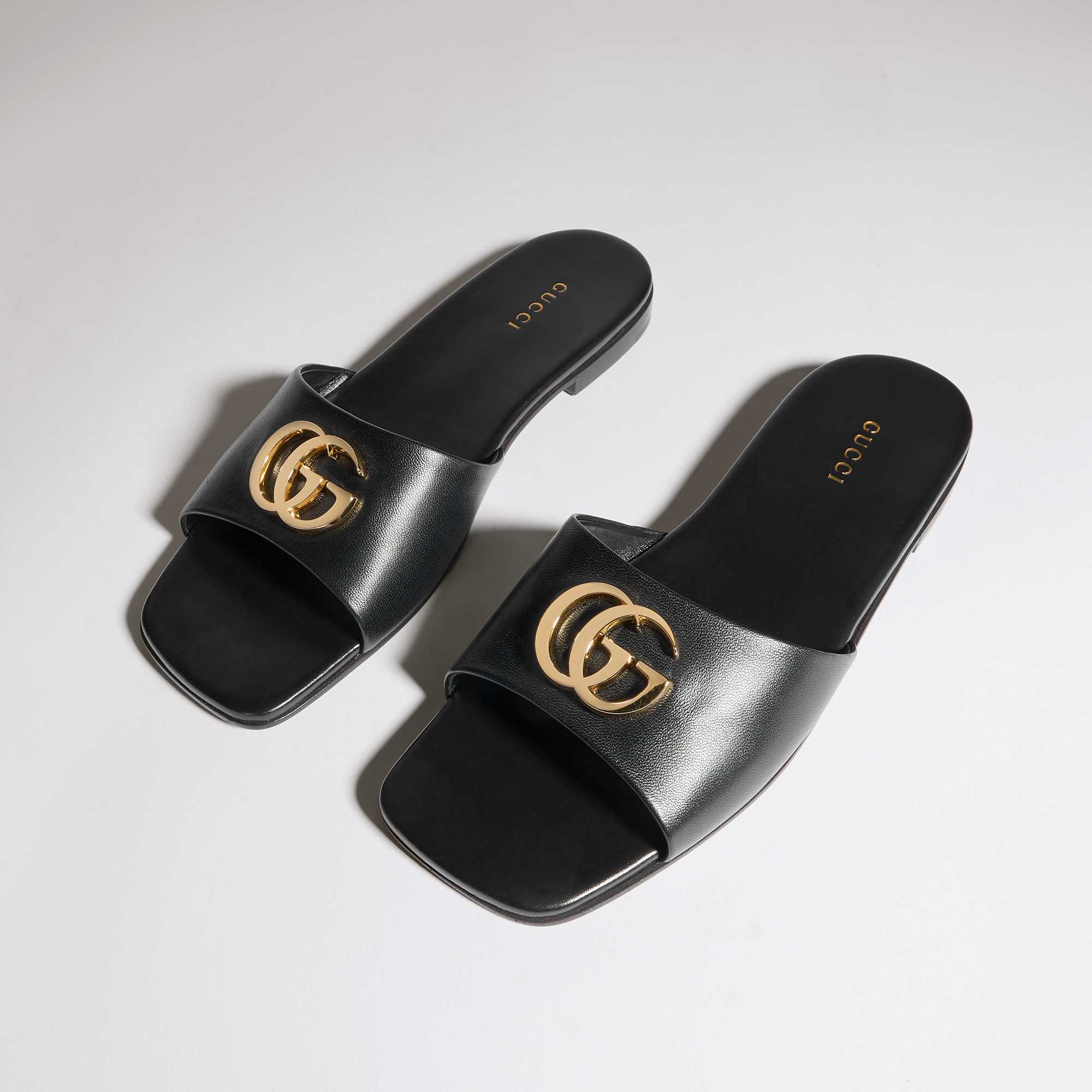 Black Gucci slides gold logo