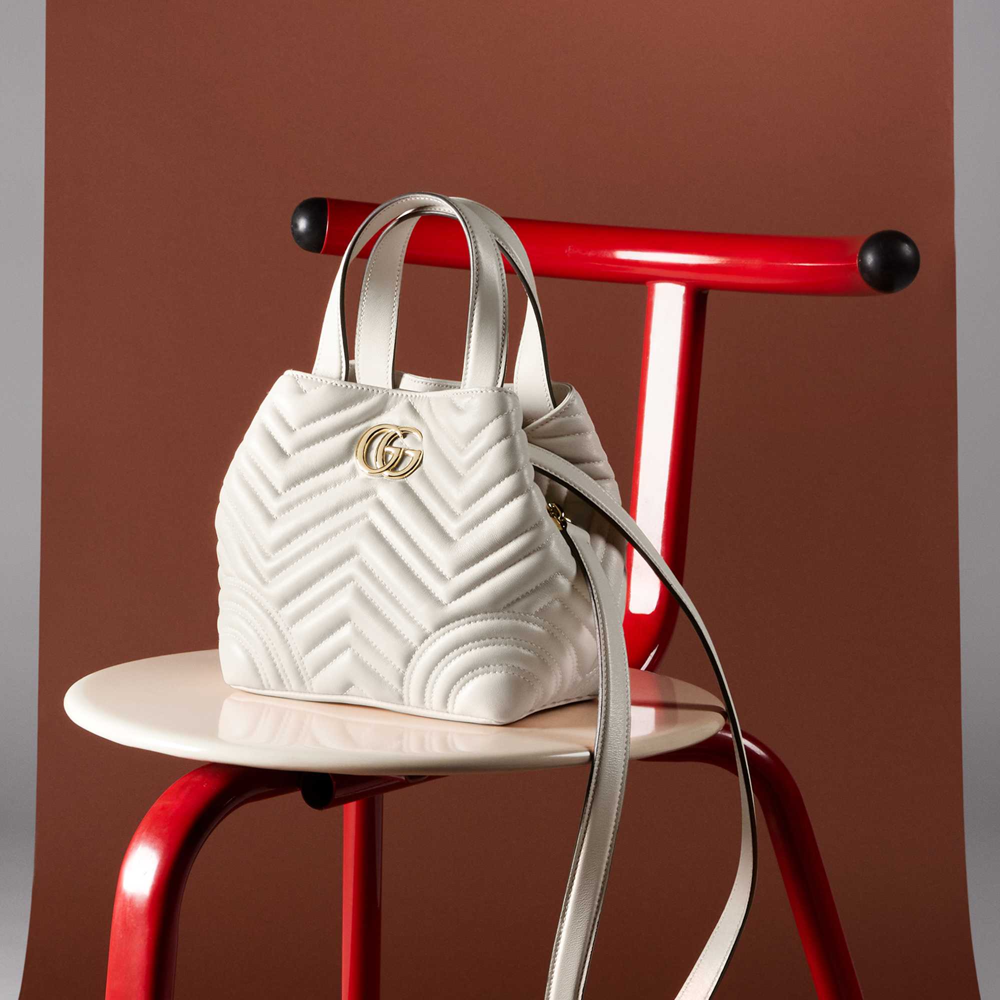 White quilted Gucci handbag displayed.