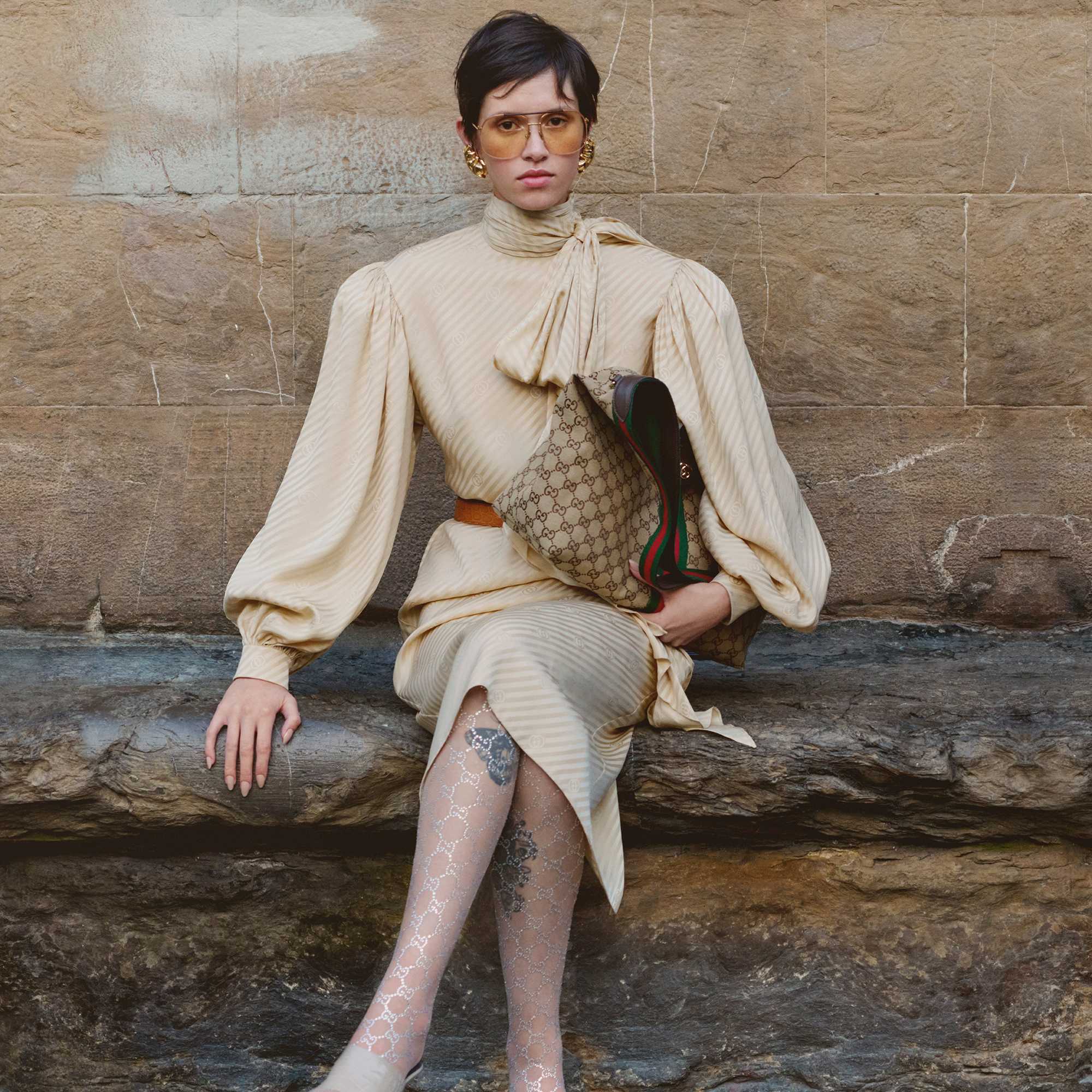 Blue Gucci sweater, brown handbag.