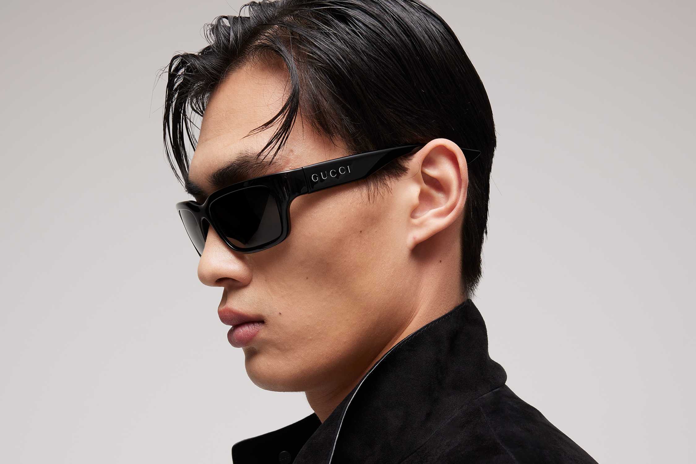Black Gucci wraparound sunglasses worn.
