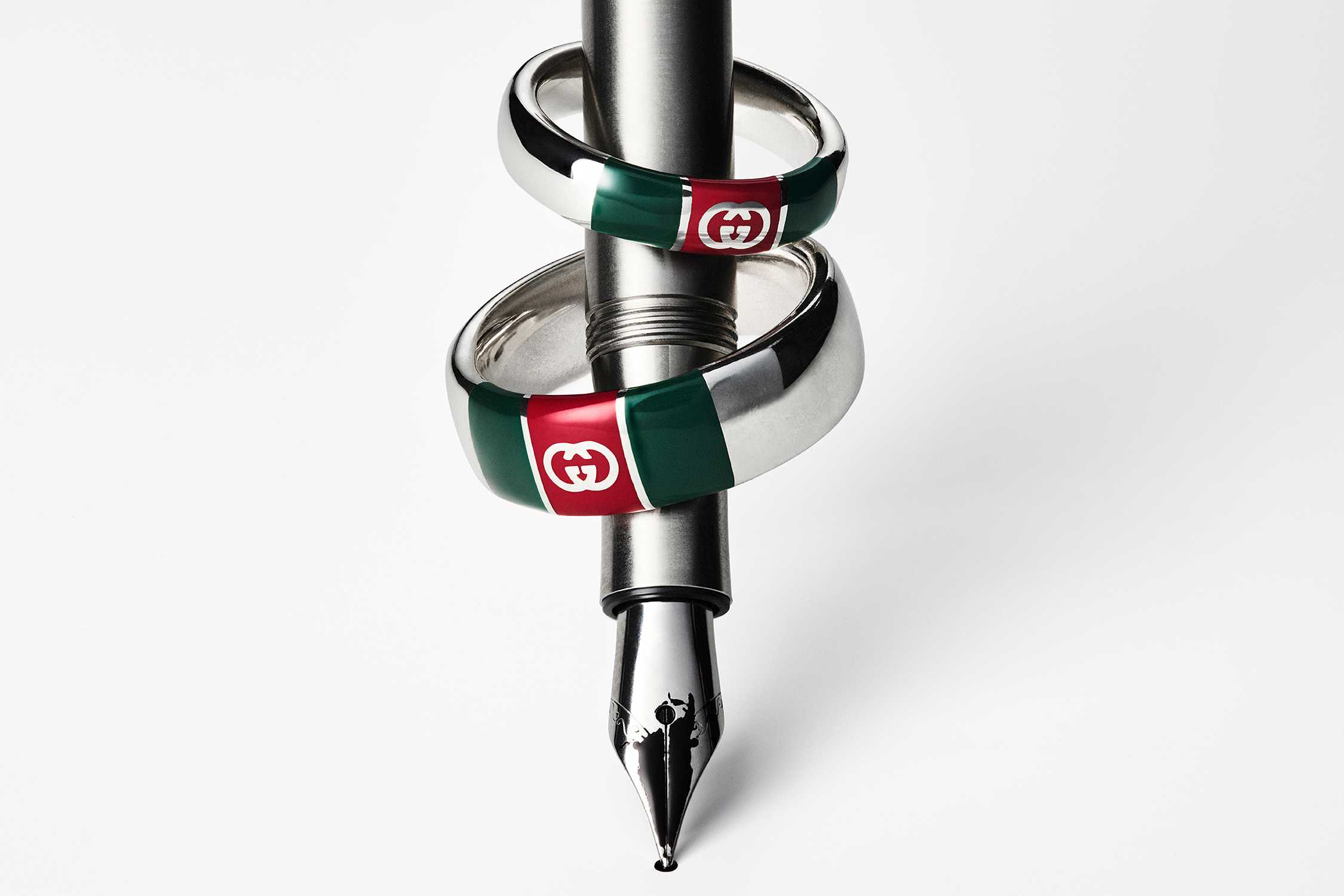 Gucci green-red-silver rings on pen