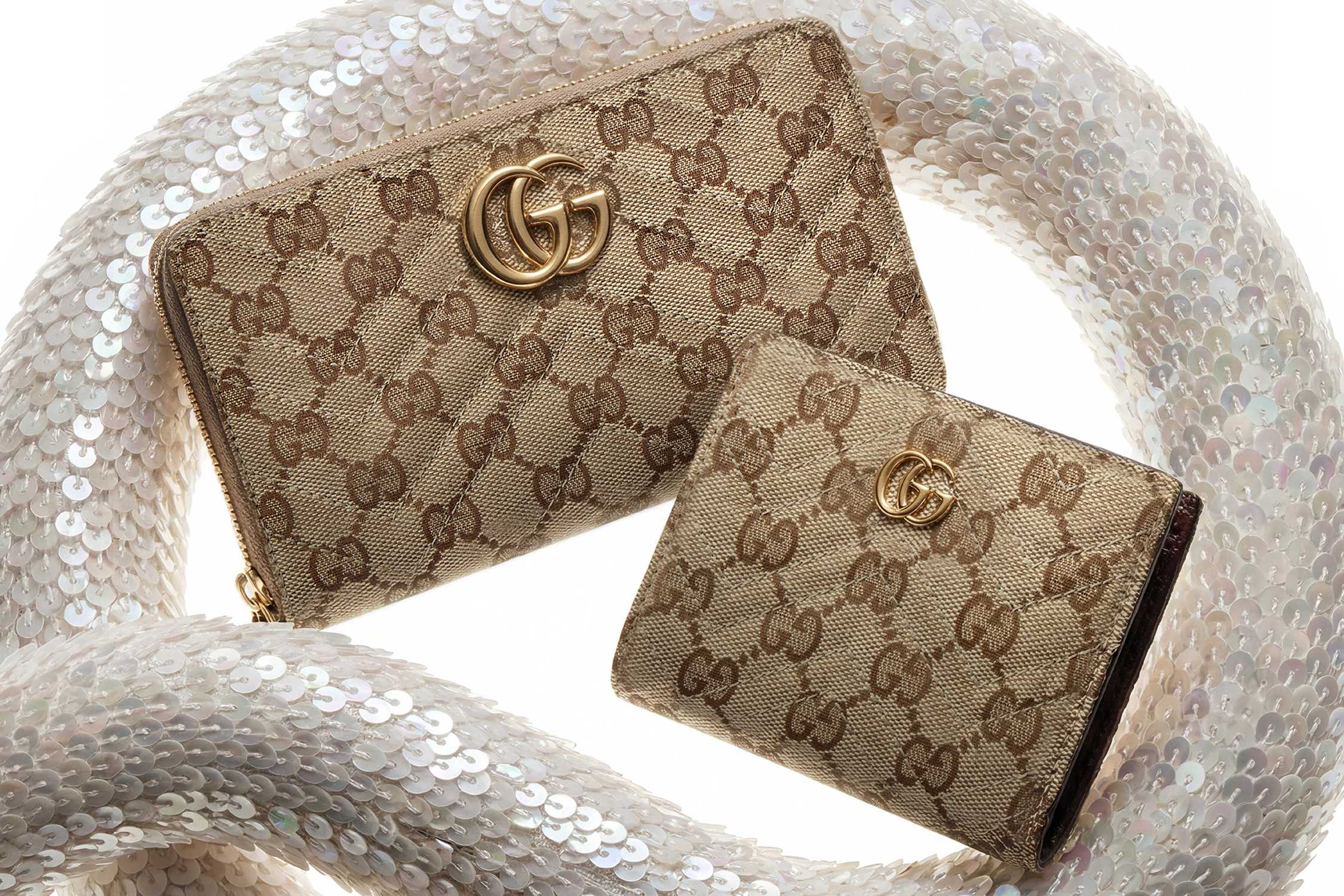 Beige Gucci wallets with gold logo.