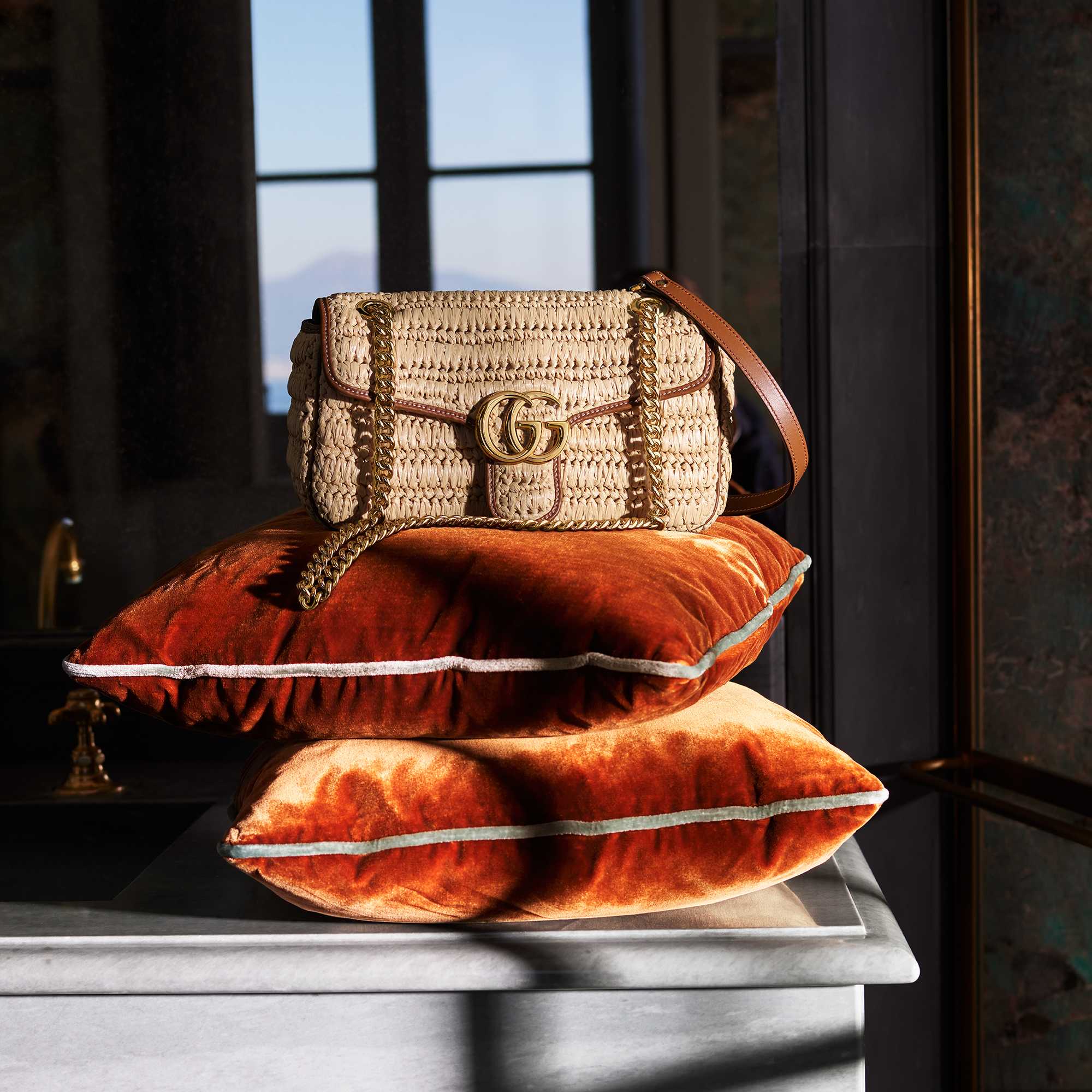 Woven GG Marmont handbag on an orange pillow