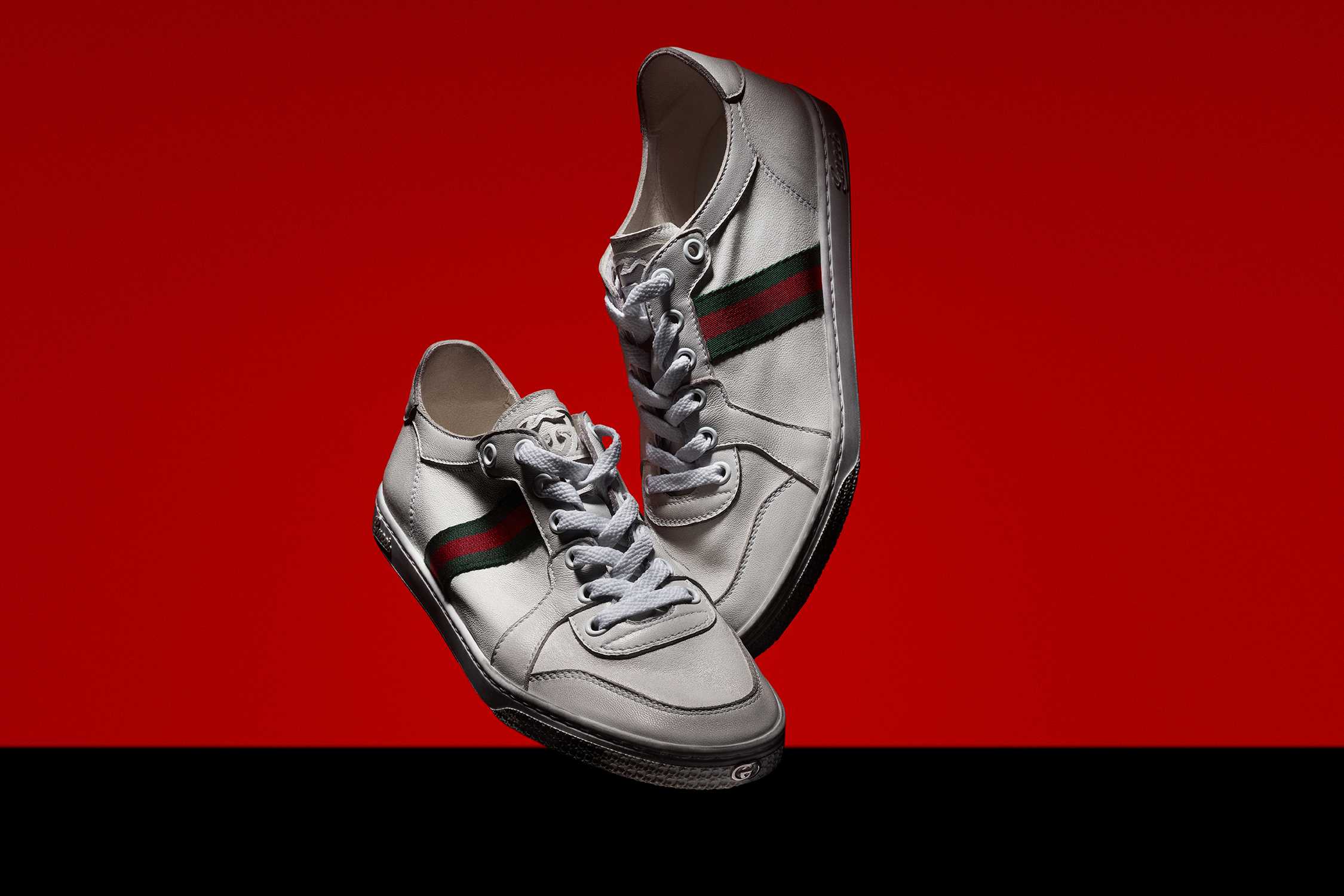 White Gucci trainers red background