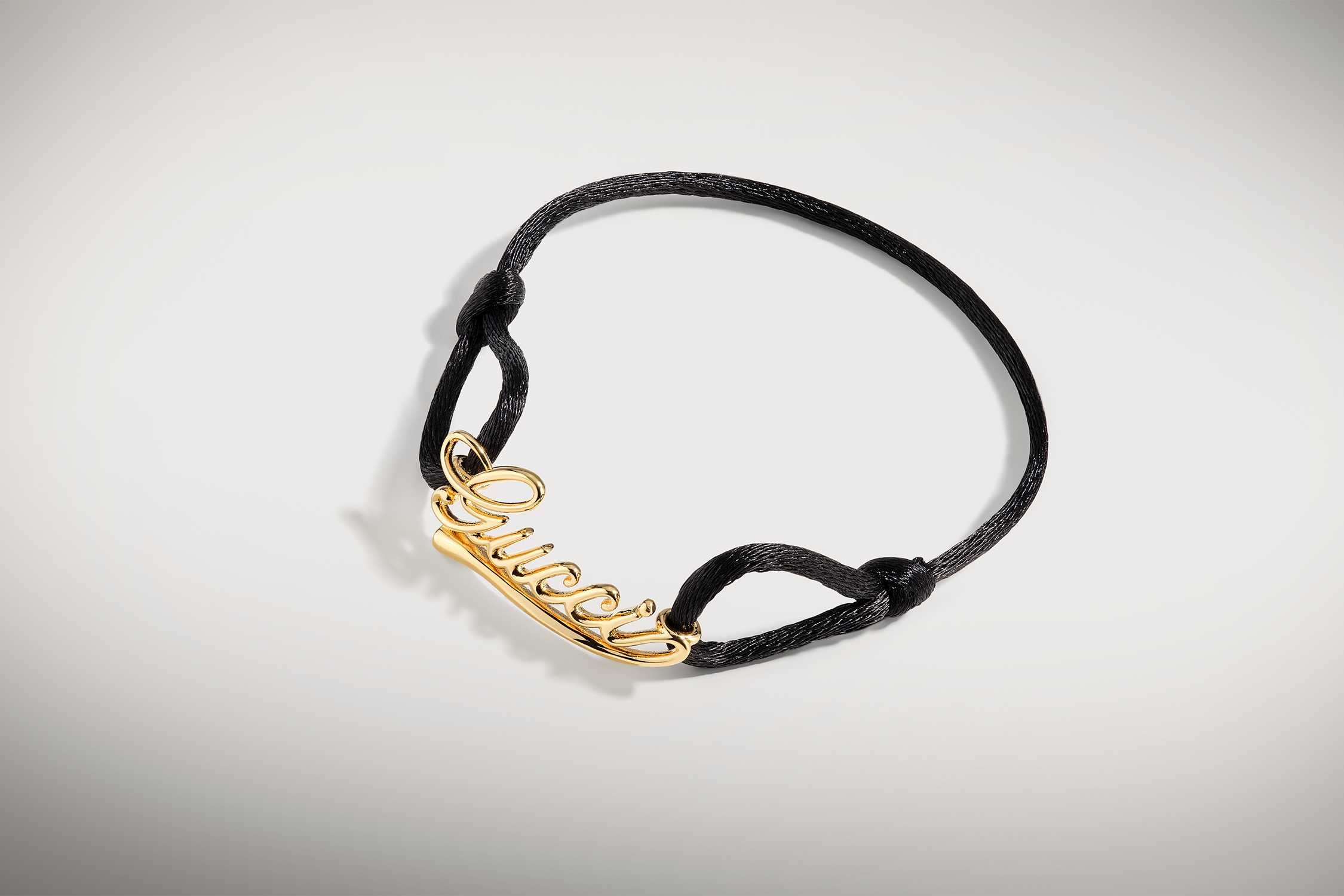 Black cord gold Gucci bracelet