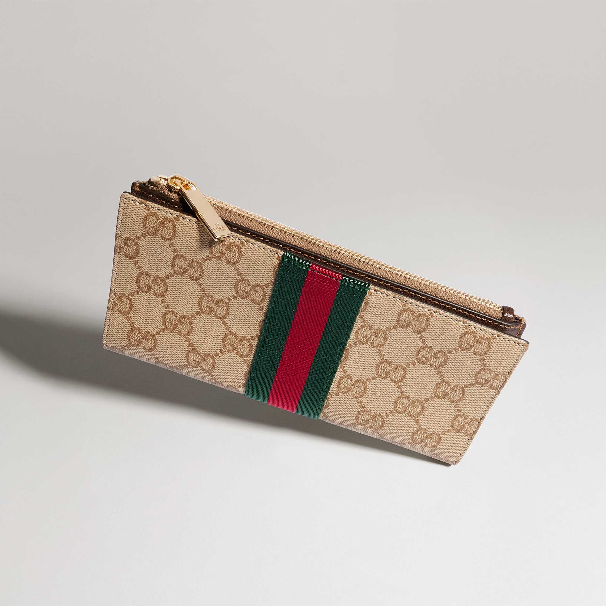 Beige Gucci wallets with red-green stripes.