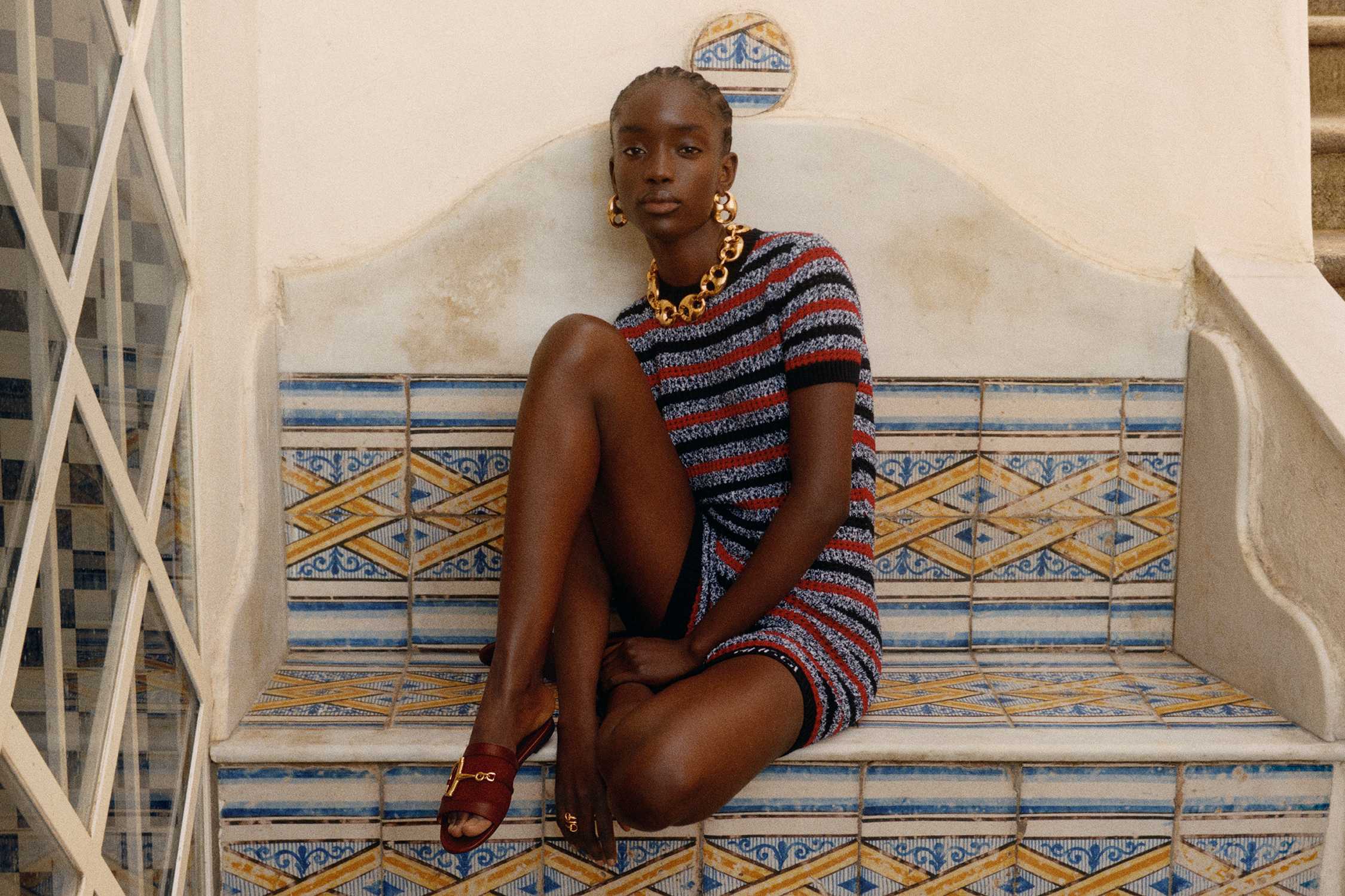 Striped Gucci dress, gold accessories.