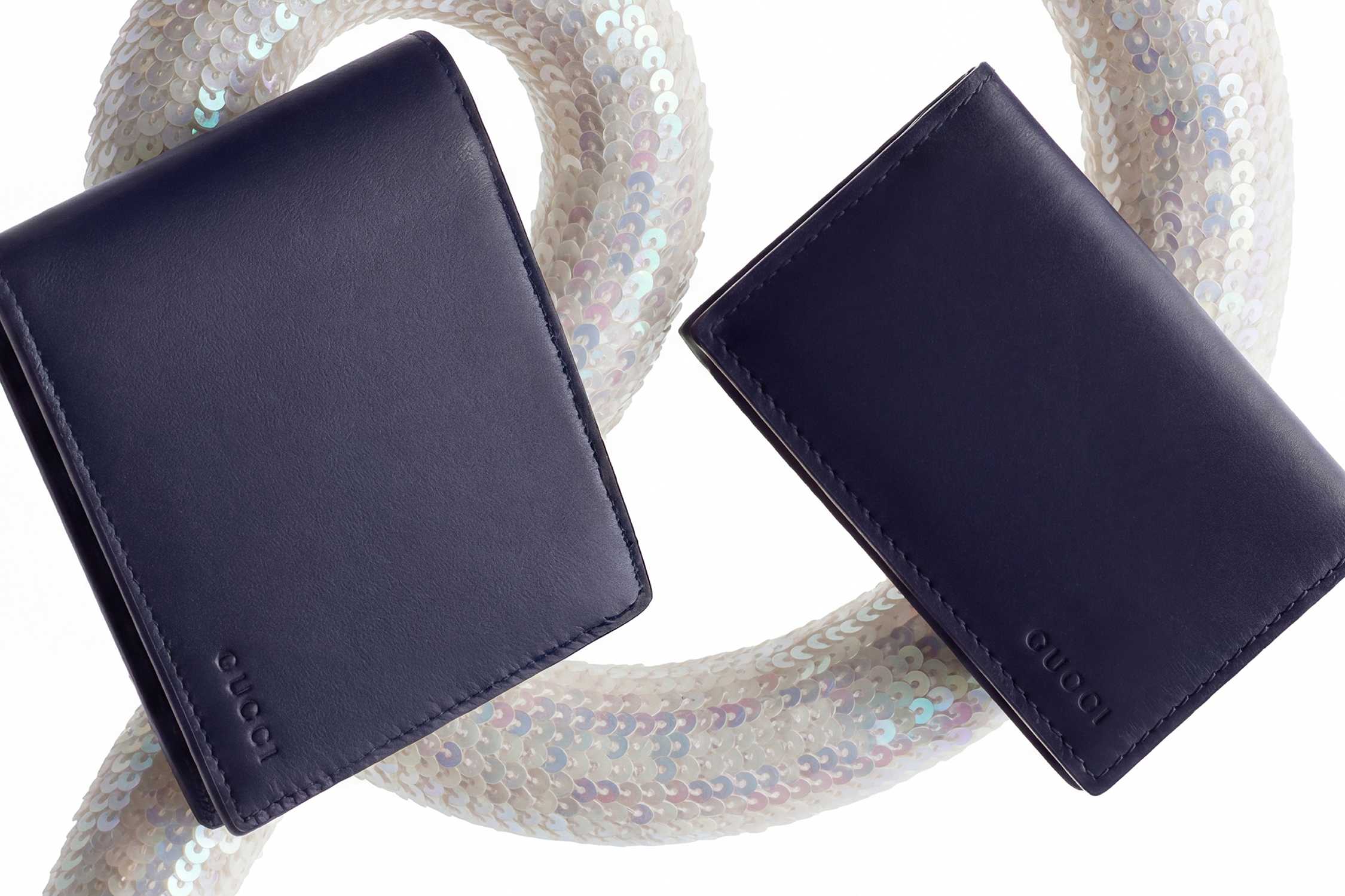 Navy Gucci wallets on sequined curve.