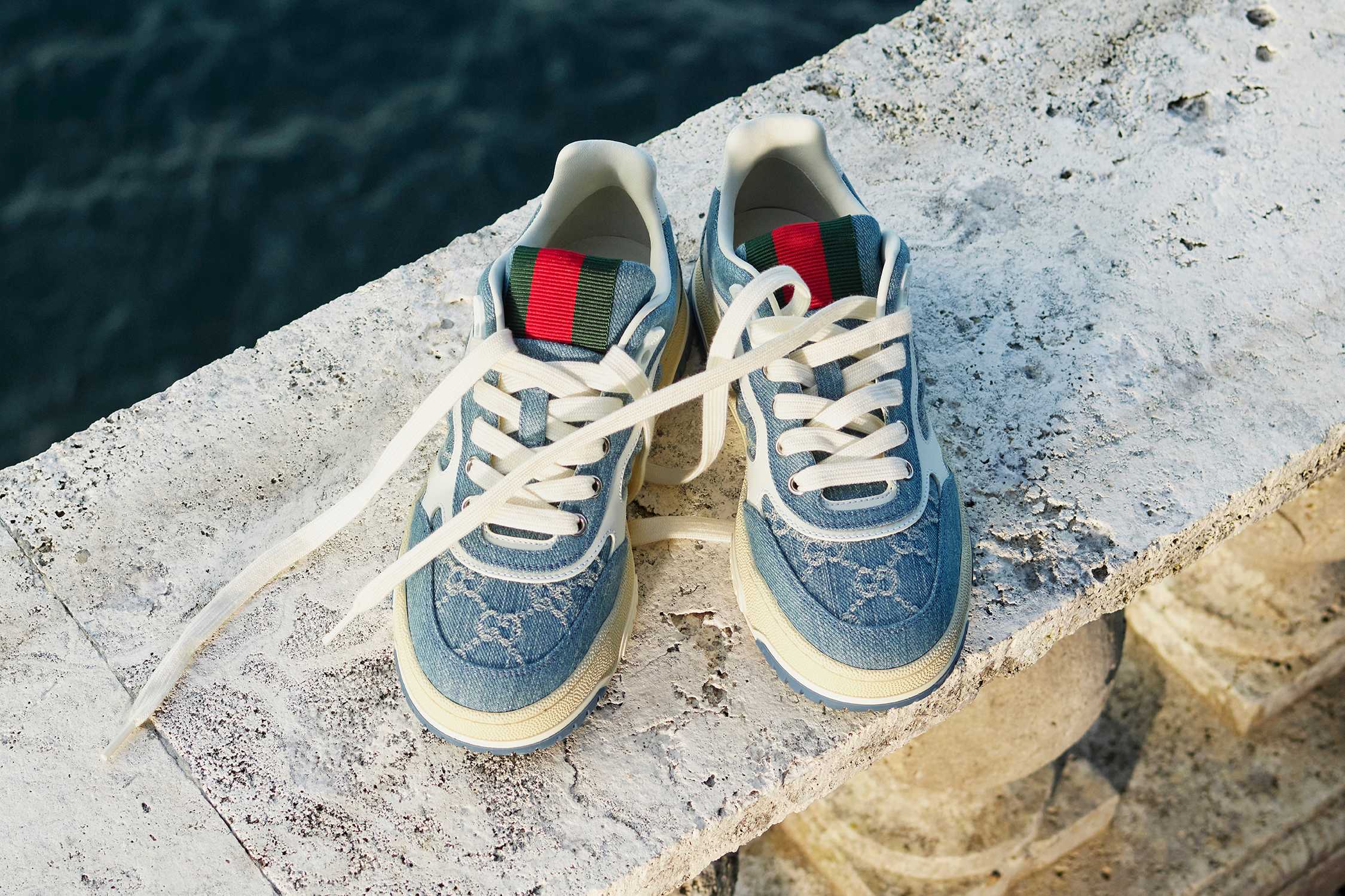 Blue denim trainers on stone ledge.