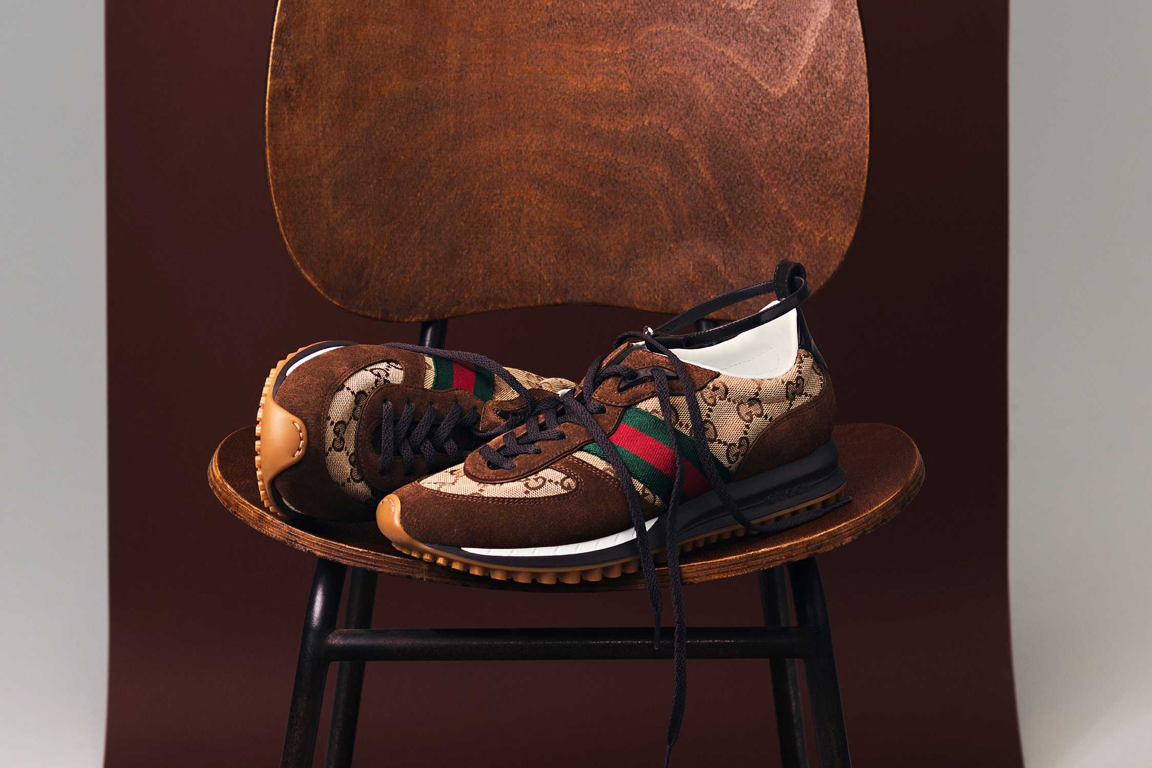 Brown Gucci monogram trainers displayed.