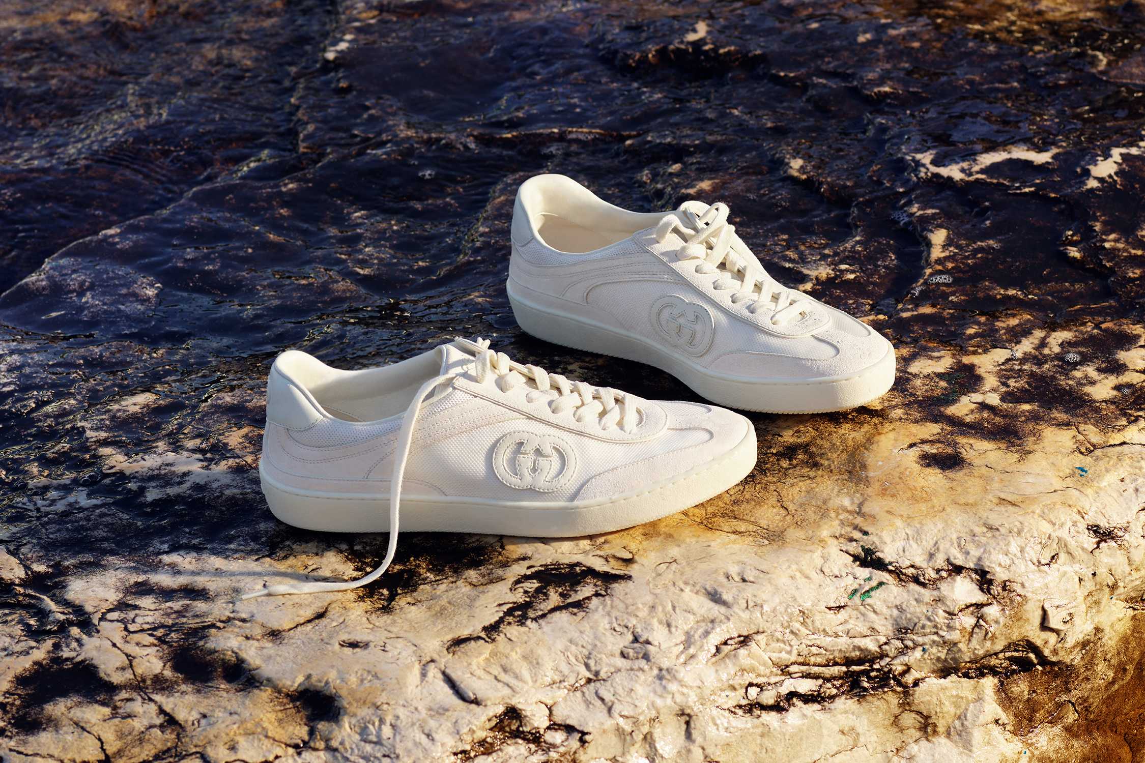 White Gucci trainers on rock
